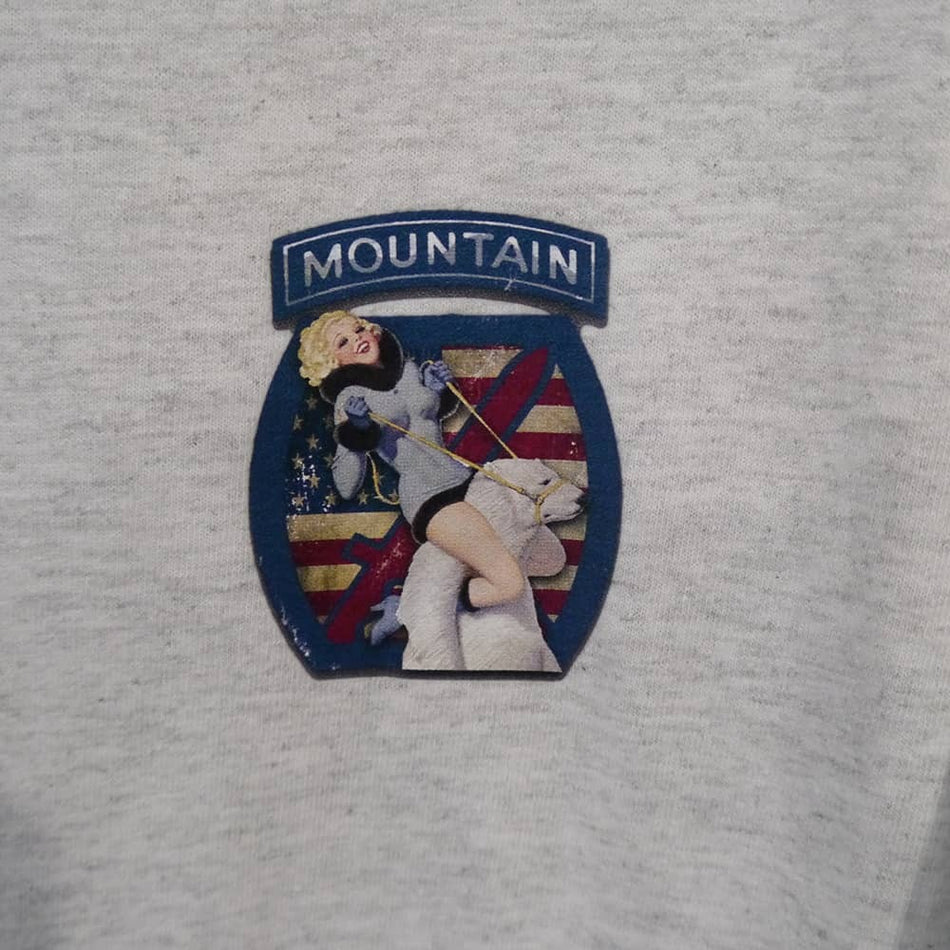 Patch on a gray fabric with 'MOUNTAIN' text and a design of a person skiing.
