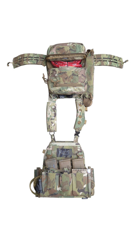 A tactical body armor carrier vest in a multi-terrain camouflage pattern, featuring a chest rig with pouches and straps, shown against a plain white background.