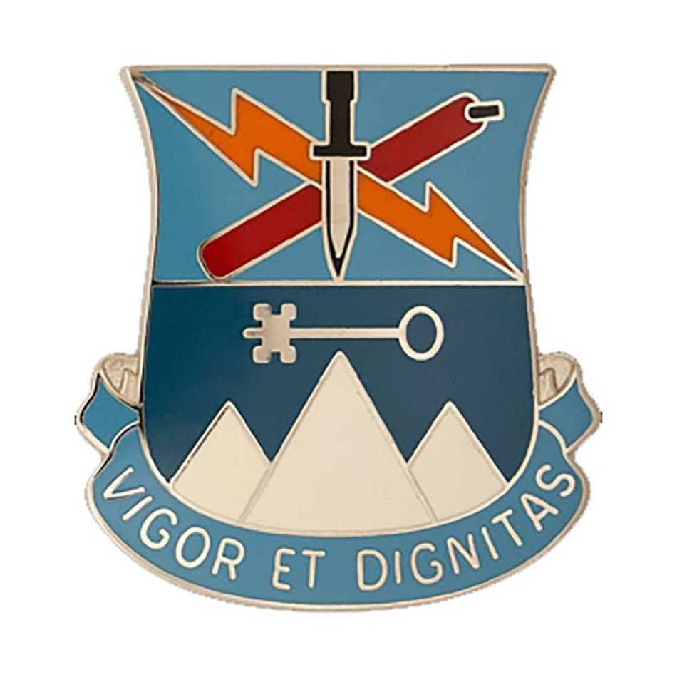 An enamel military-style crest pin with a shield shape, featuring crossed red and orange lightning bolts, a silver dagger, a silver key, white mountain peaks, and a blue scroll reading “VIGOR ET DIGNITAS” on a white background.