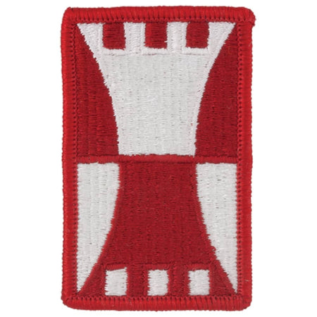 A rectangular embroidered patch featuring a red and white castle-like emblem on a plain white background.