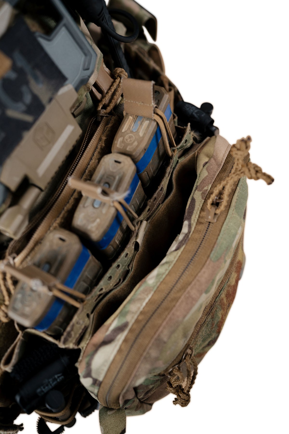 Close-up of tactical gear including a camouflage utility pouch and a tan tactical vest or magazine carrier with blue accents, isolated on a white background.
