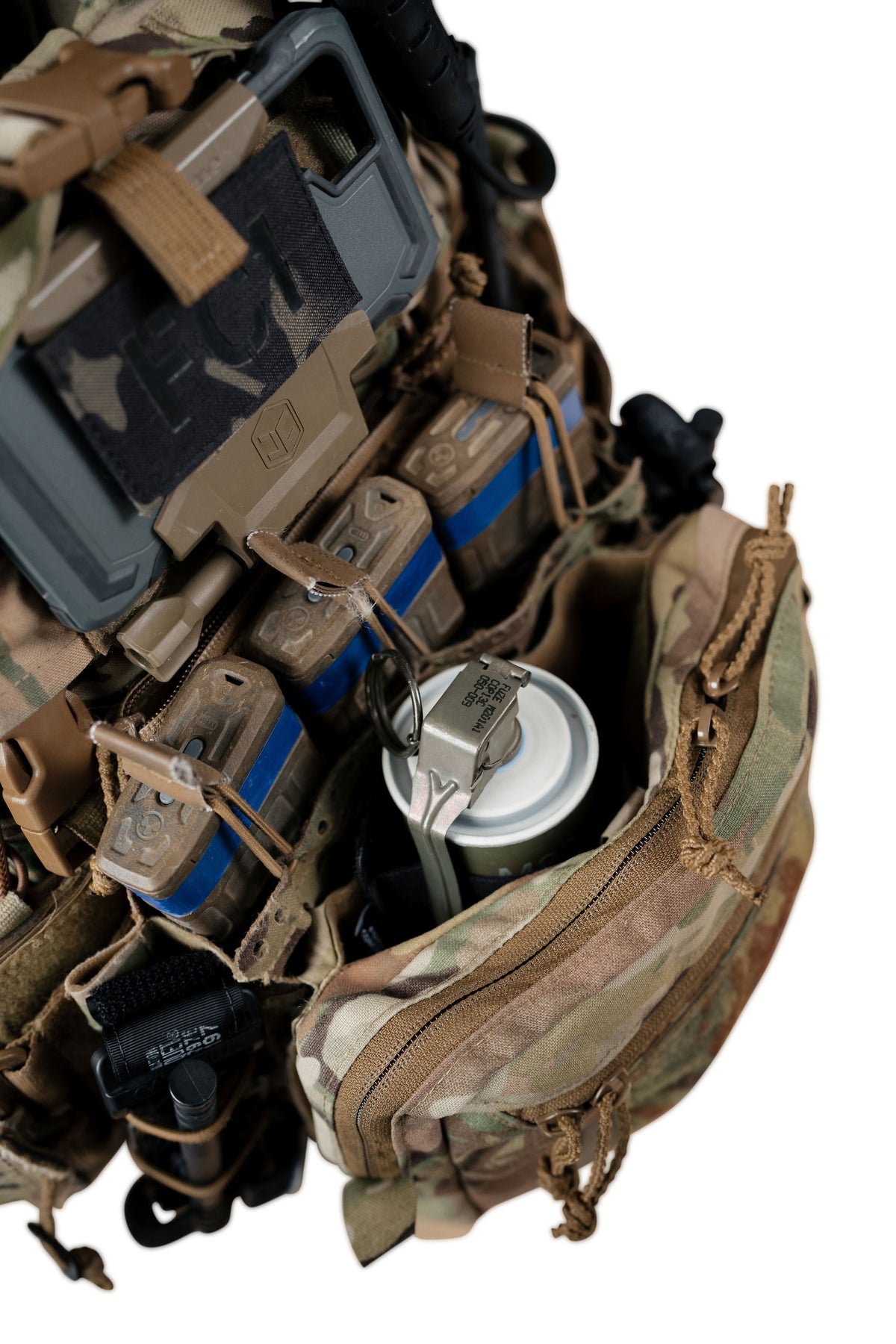 Close-up of tactical gear and a camouflage backpack pouch with straps, containers, and gear attachments on a white background.