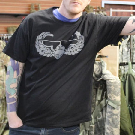 Person wearing a black t-shirt with a graphic design in a clothing store.