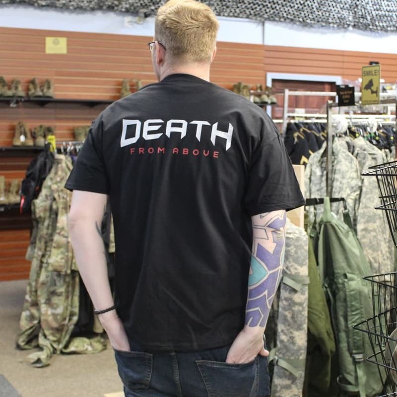Person wearing a black t-shirt with 'DEATH FROM ABOVE' text in a store setting