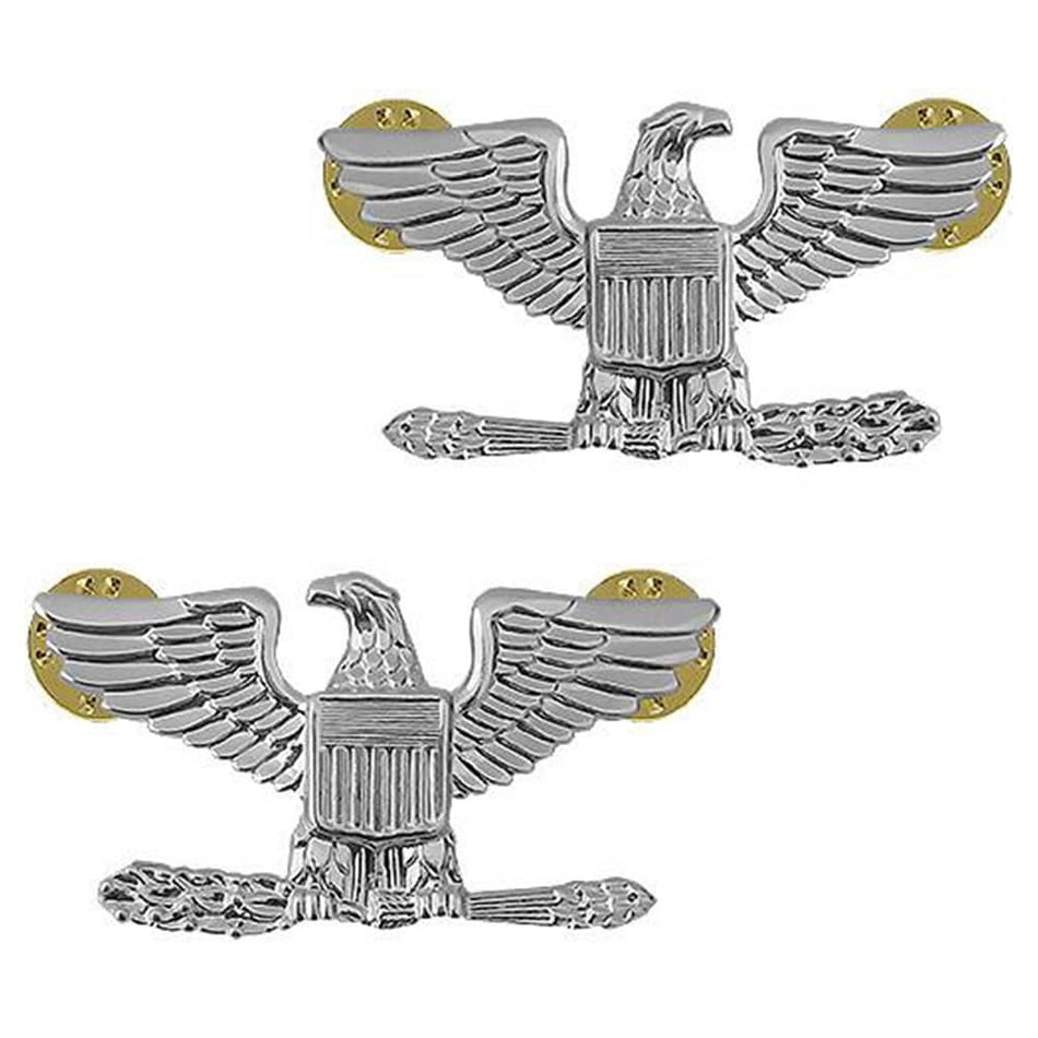 Two silver eagle insignia pins with gold-toned circular backings, shown on a plain white background.