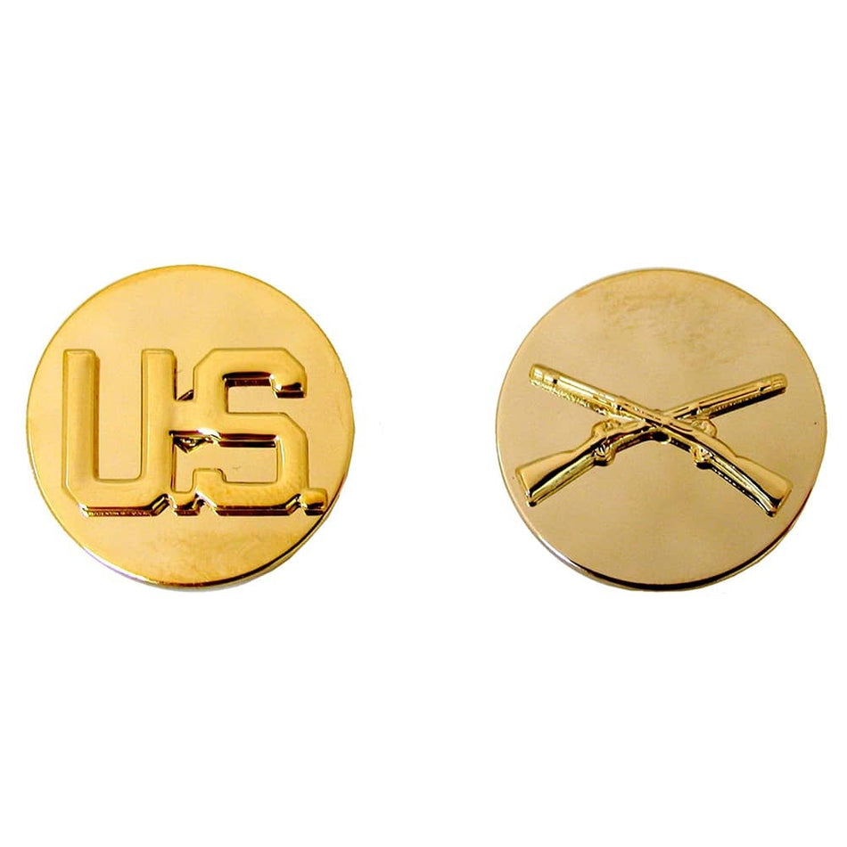 Two round gold military-style insignia pins on a white background, one showing the raised letters 'US' and the other showing crossed rifles.