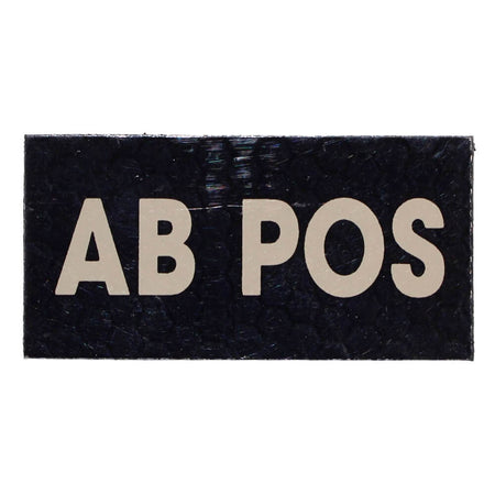 A rectangular black patch with the text 'AB POS' in large beige capital letters, shown on a plain white background.