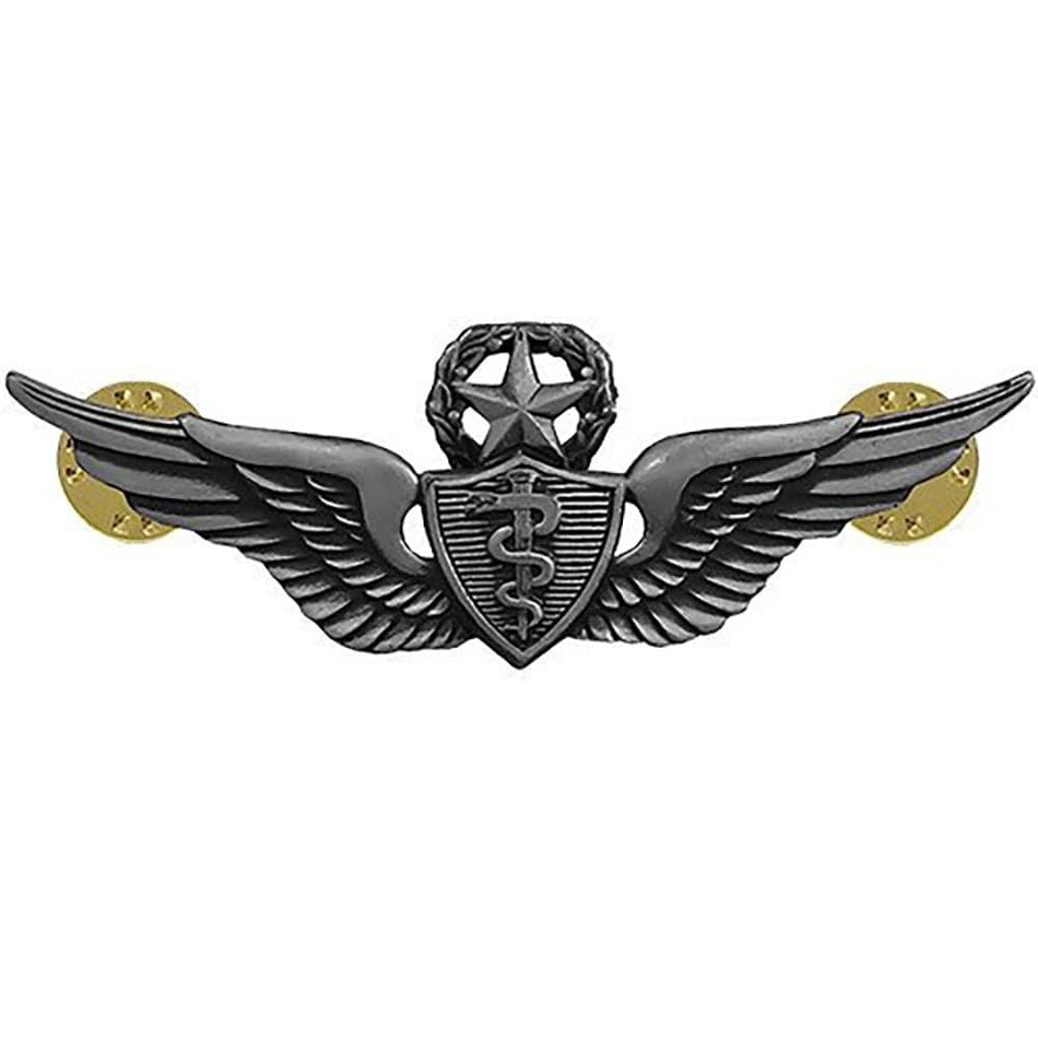 A military-style winged emblem with a dark metallic gray finish and gold-toned circular mounts on each side, shown on a plain white background.
