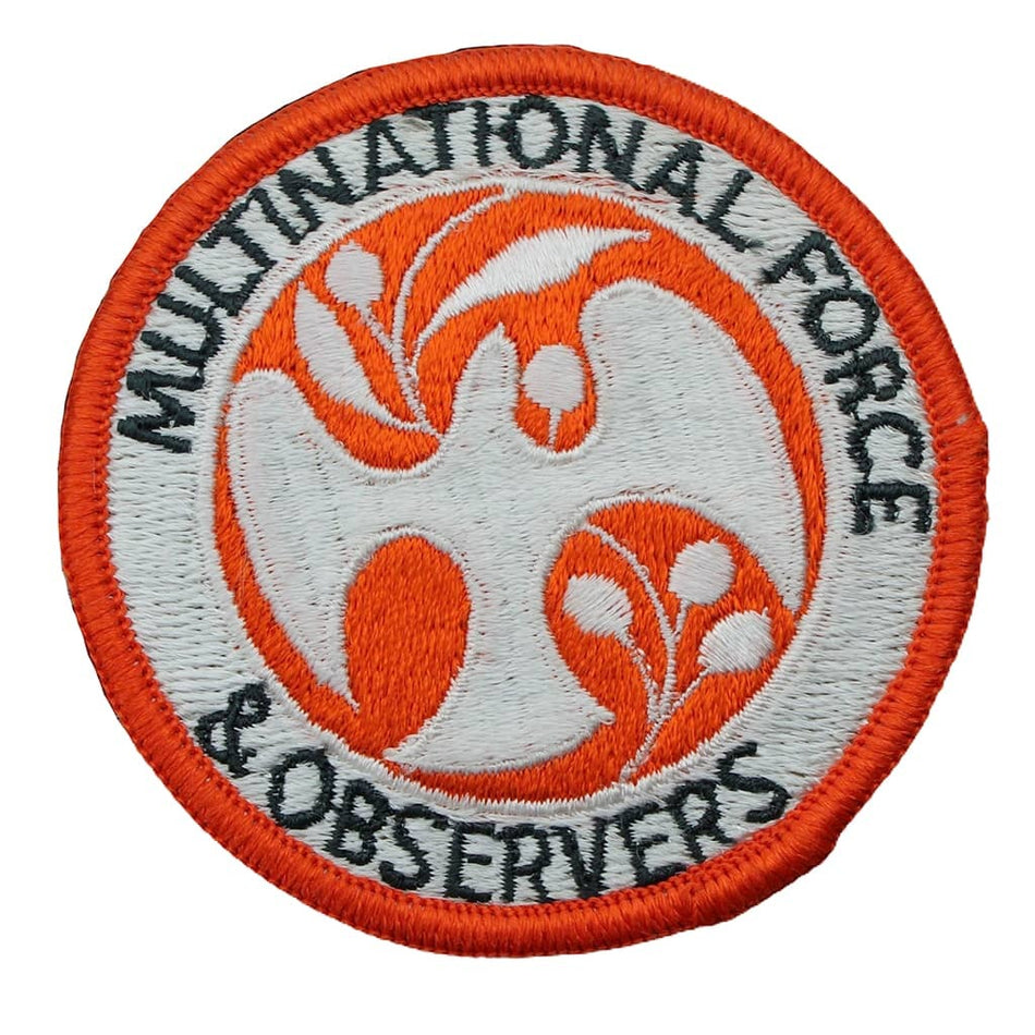Army Multi-National Force and Observers circular embroidered patch with an orange border, white center, and orange abstract floral-like motifs. Black text around the patch reads “MULTINATIONAL FORCE & OBSERVERS.