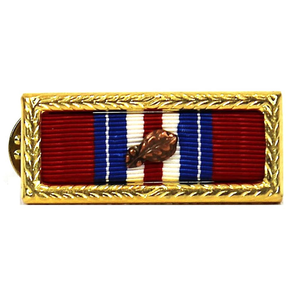A rectangular military-style ribbon pin with a gold-toned decorative border, featuring red, white, and blue vertical stripes with a central brown leaf emblem, shown on a plain white background.