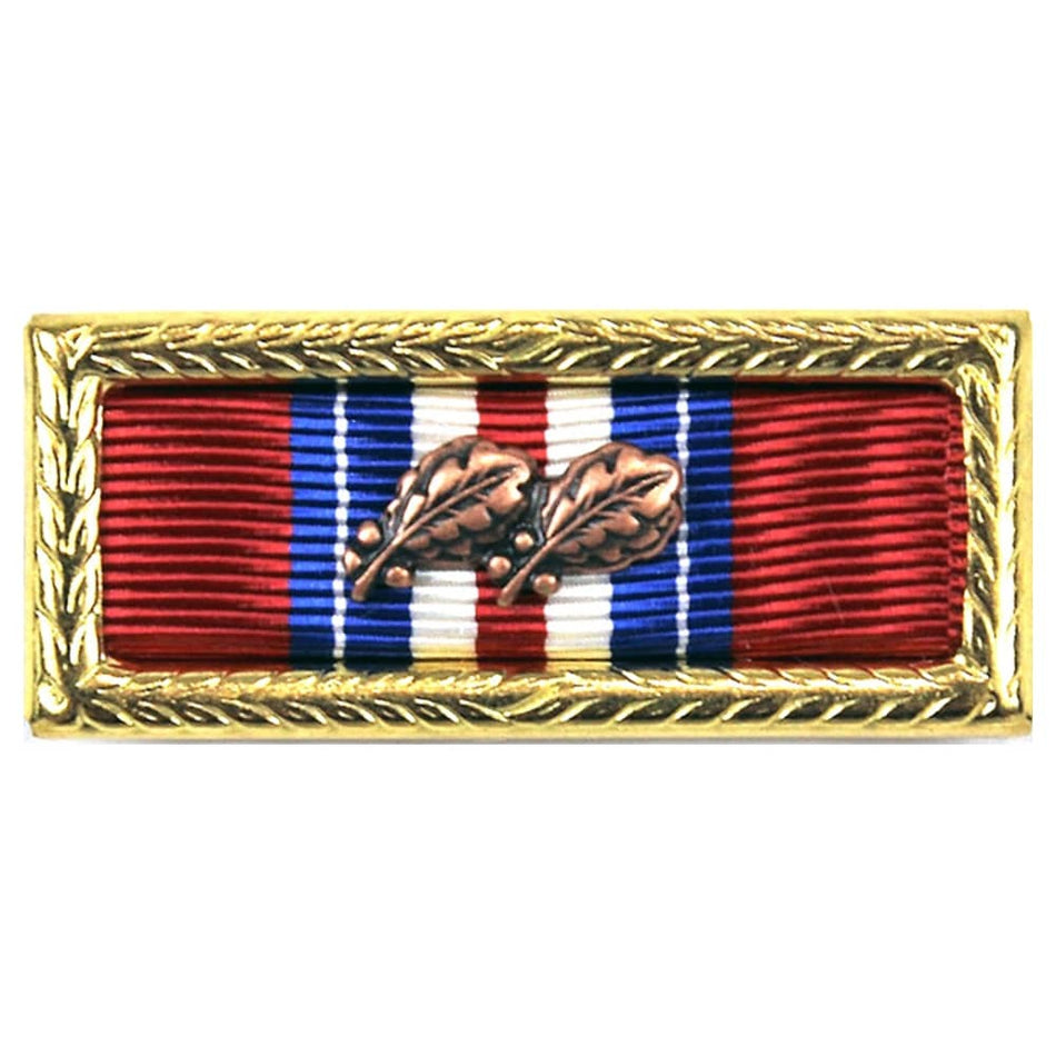 A rectangular military-style medal ribbon pin with a gold-toned decorative border, featuring red, white, and blue ribbons and two brown leaf motifs in the center, shown on a plain white background.