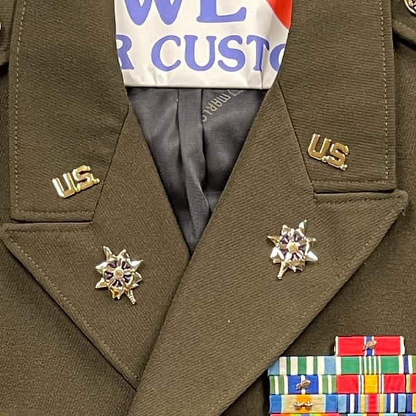 Close-up of a military uniform with U.S. pins and ribbons.