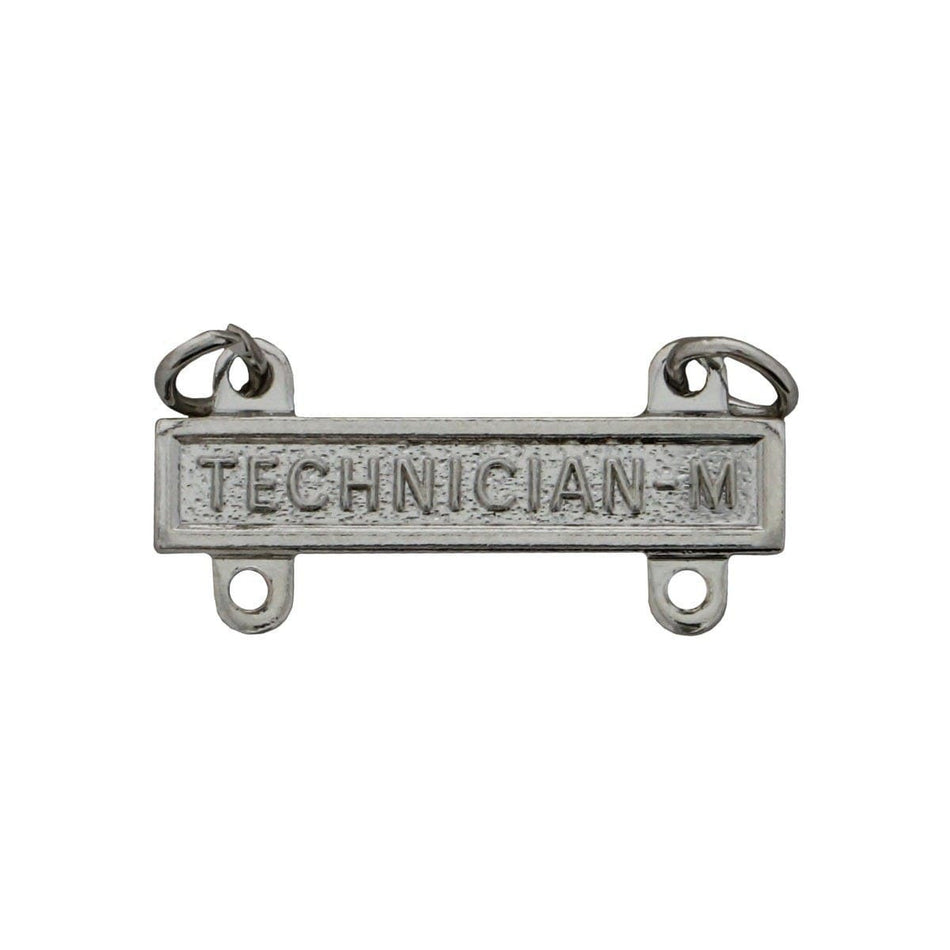 A rectangular silver-toned metal badge or emblem with the embossed text 'TECHNICIAN-M' and two small hanging loops at the top, shown on a plain white background.