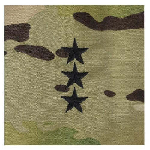Close-up of a camouflage fabric with three black embroidered stars arranged vertically on the right side.