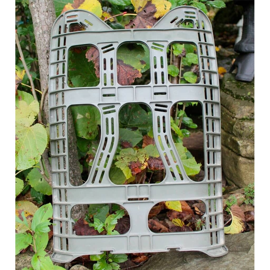 Plastic Molded Frame for Large Rucksack with a slatted grid design, shown leaning against a tree trunk in a garden setting with green and brown leaves.