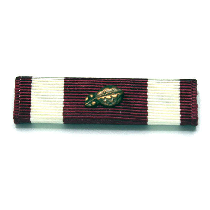 A military ribbon bar featuring alternating vertical stripes of dark burgundy and off-white, with a small gold oak leaf emblem centered on the ribbon.