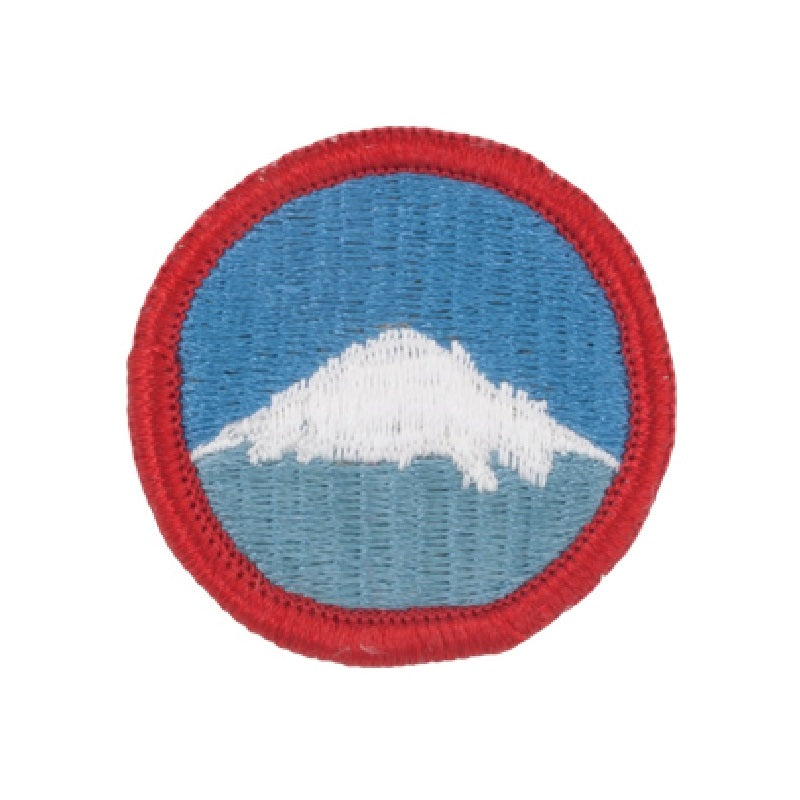 A circular embroidered patch featuring a white mountain peak against a blue sky, with a red stitched border, shown on a plain white background.