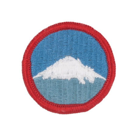 A circular embroidered patch featuring a white mountain peak against a blue sky, with a red stitched border, shown on a plain white background.