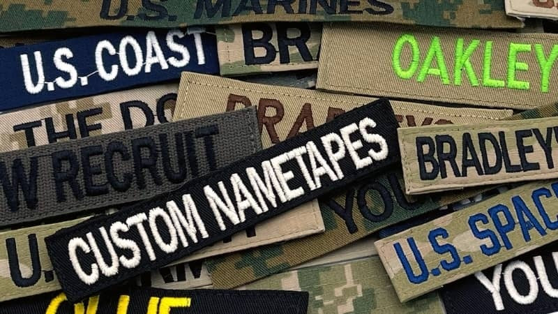 Collection of custom nametapes with various text on a camouflage background