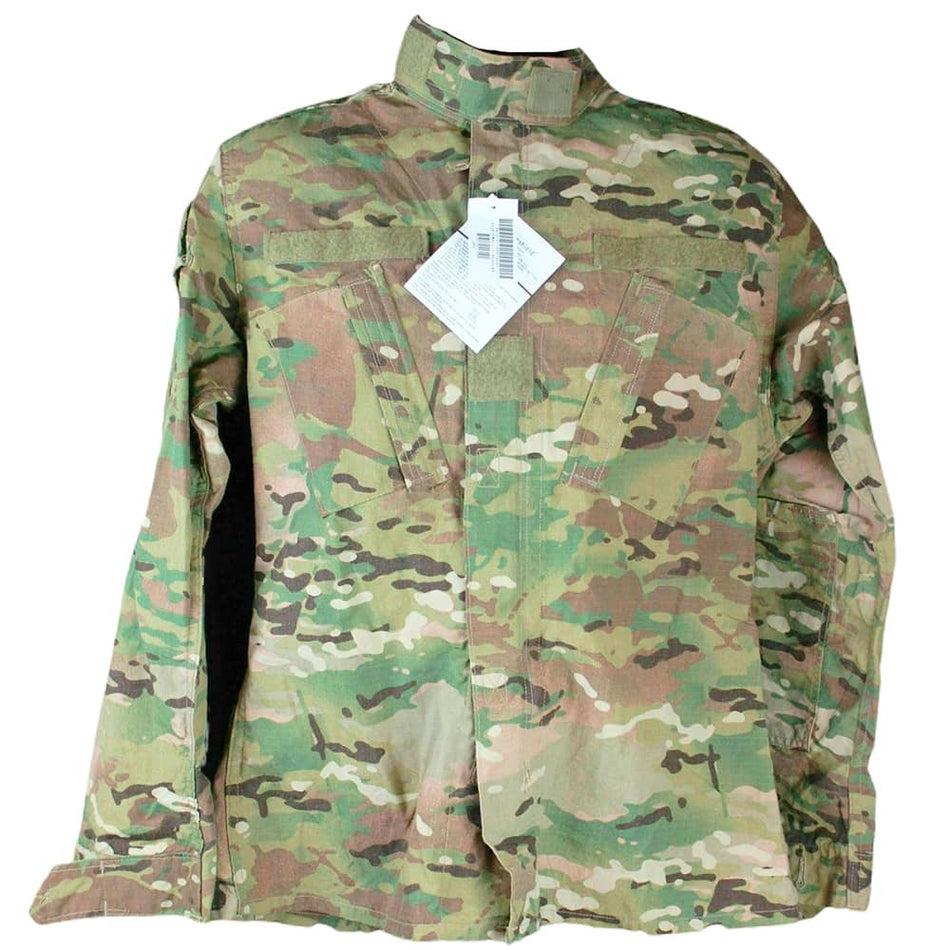 A long-sleeve military combat utility jacket in a multicam camouflage pattern, featuring a high collar, front flap pockets, and a white product tag attached at the neck.
