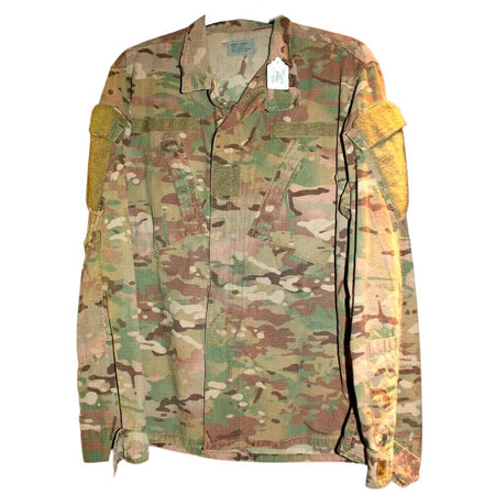 A military-style camouflage utility jacket with tan shoulder patches, shown flat against a white background.