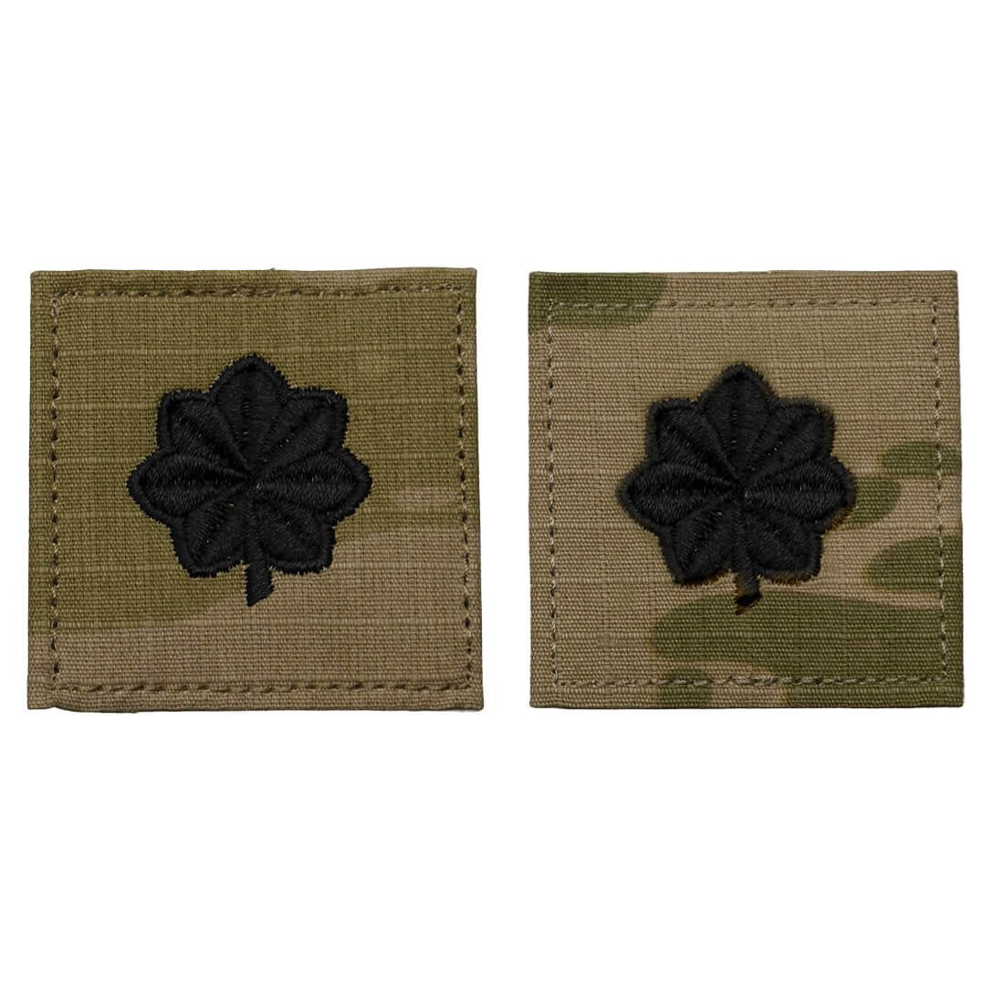 Two rectangular embroidered patches on a white background. Each patch has a black four-leaf clover design on a tan and olive drab camouflage fabric base.