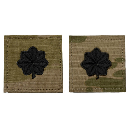 Two rectangular embroidered patches on a white background. Each patch has a black four-leaf clover design on a tan and olive drab camouflage fabric base.