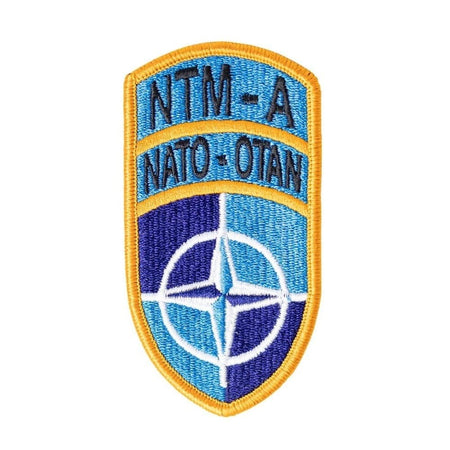 NATO patch with blue and yellow colors on a white background