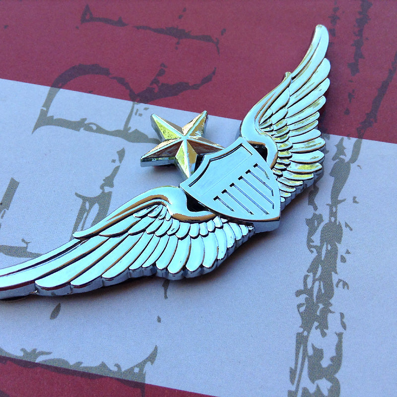 Metallic winged badge with star on a textured background