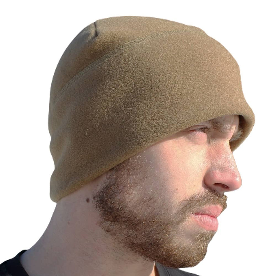 A man in profile wearing a soft tan fleece beanie hat against a plain white background.