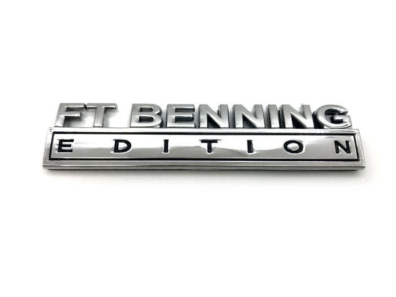 A metallic chrome emblem badge reading 'FT BENNING EDITION' on a plain white background.