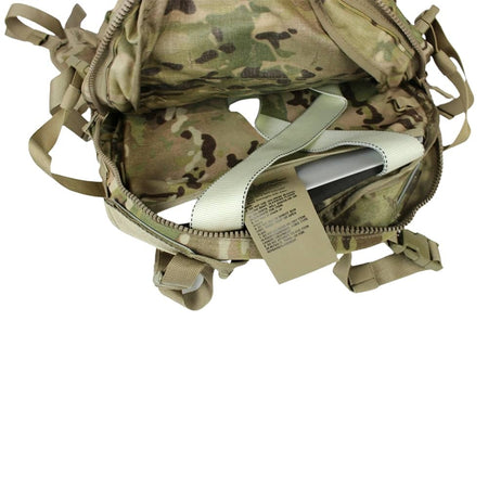 An open tactical backpack in Multicam camouflage pattern, showing the interior compartments, zipper details, and a light beige webbing strap with a product tag.