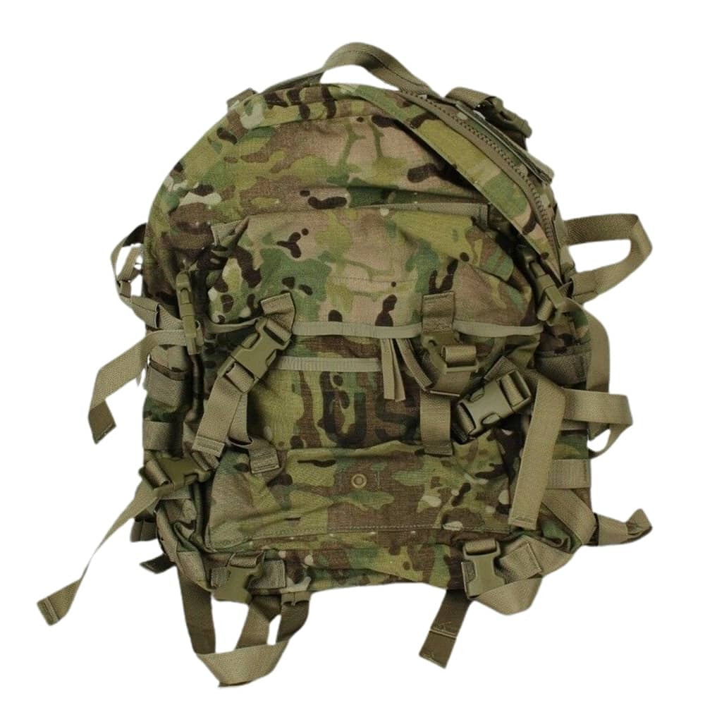 A tactical backpack in a multi-terrain camouflage pattern, featuring multiple straps, buckles, and compression points, shown against a plain white background.