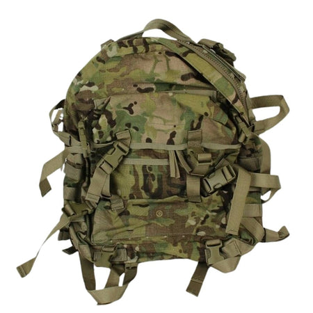 A tactical backpack in a multi-terrain camouflage pattern, featuring multiple straps, buckles, and compression points, shown against a plain white background.