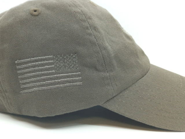 An olive drab baseball cap featuring an embroidered American flag on the side, shown against a plain white background.