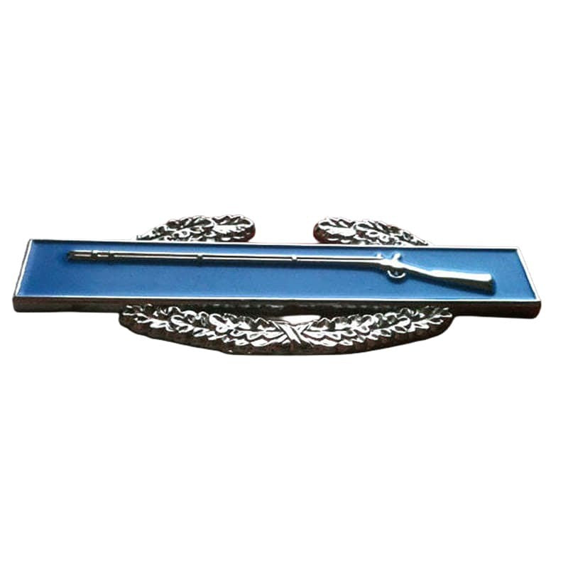 A silver-toned military insignia pin depicting a rifle resting on a laurel wreath, mounted on a rectangular blue enamel base, shown against a plain white background.