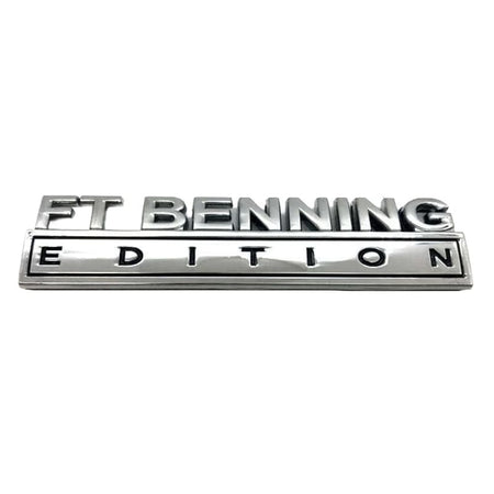 A metallic chrome emblem badge reading 'FT BENNING EDITION' on a plain white background.