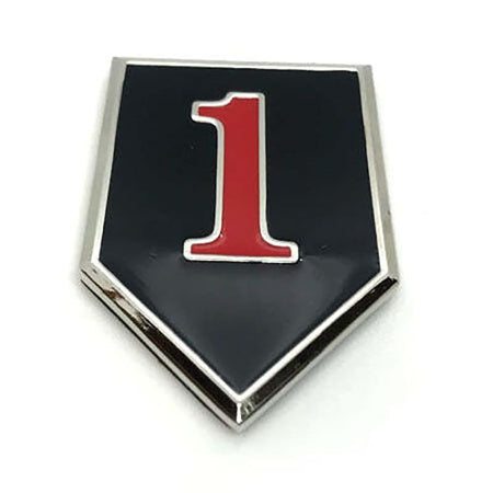 A shield-shaped enamel pin with a black center, a polished silver border, and a bold red number '1' outlined in white in the middle, shown on a plain white background.