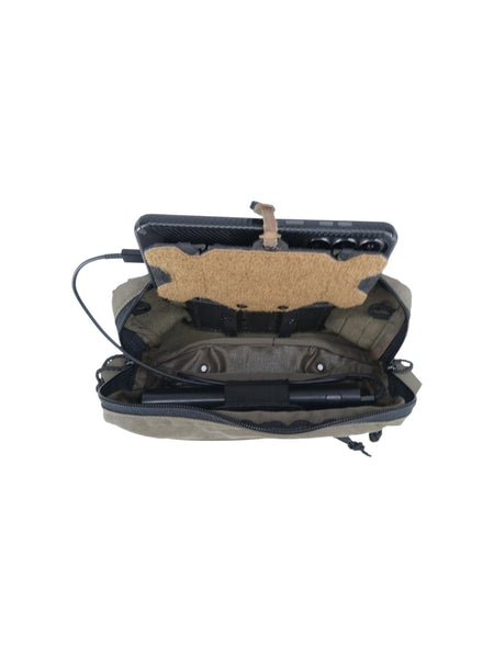 An open tactical gear case in olive drab and black, showing its interior compartments, a tan foam insert, and a black cylindrical accessory inside, photographed on a plain white background.